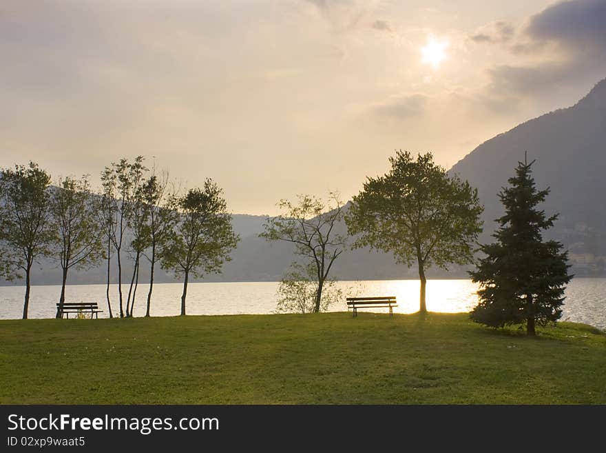 Bench by the lake and trees in autumn