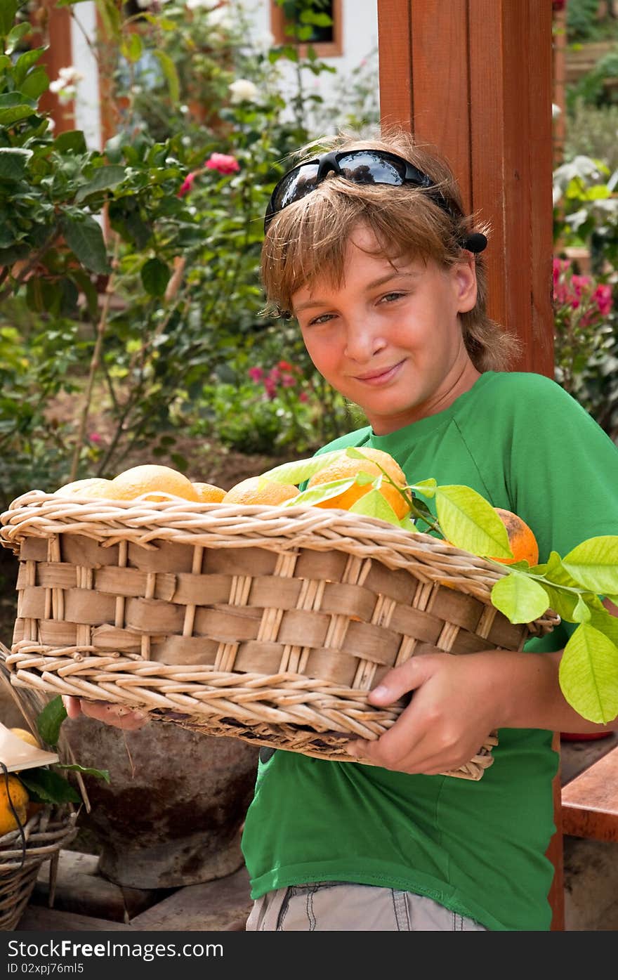 A boy carries a basket of oranges. A boy carries a basket of oranges.