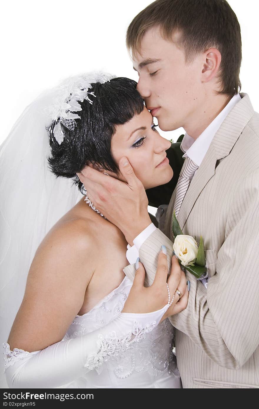 Loving groom and beautiful bride are happy together. A white background.