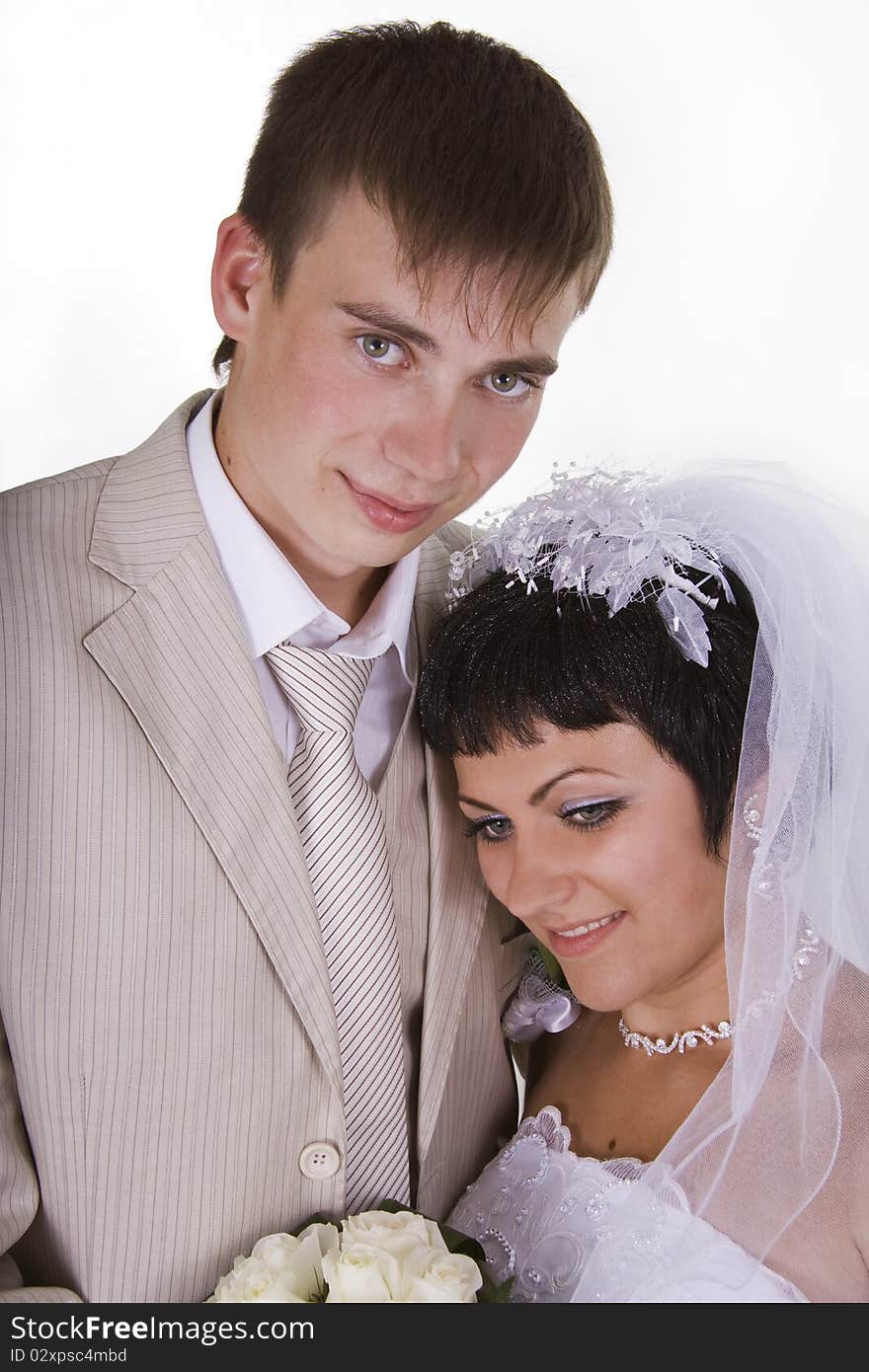 Loving groom and beautiful bride are happy together. A white background.