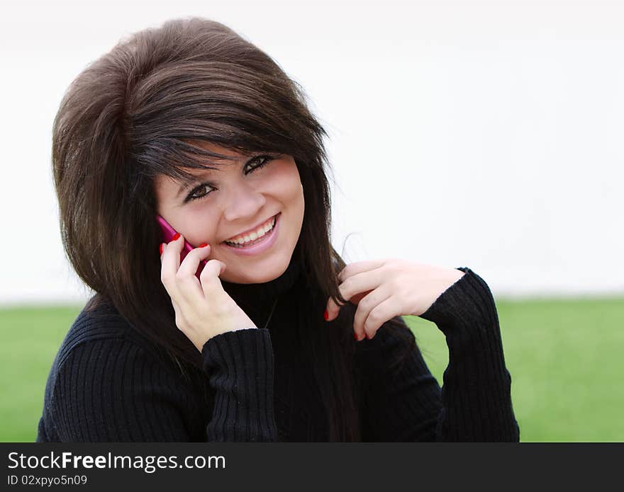 Beautiful teenage girl talking on the phone outside. Beautiful teenage girl talking on the phone outside