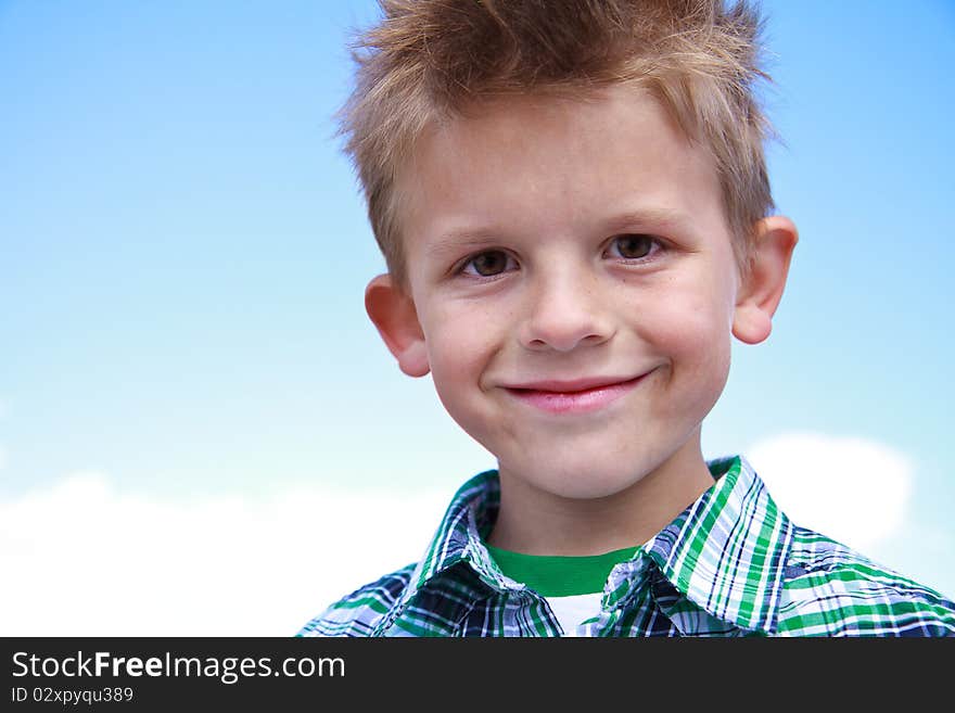 Cute little boy smiling at the viewer and wearing stripes on a white background. Cute little boy smiling at the viewer and wearing stripes on a white background