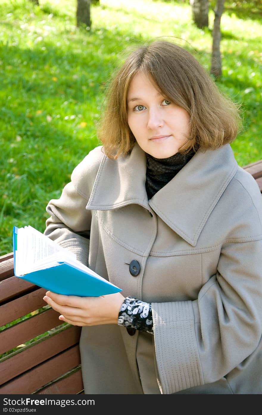 Attractive woman is reading a book outdoor