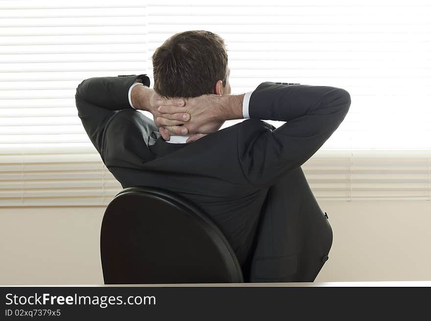 Rear view of a relaxed businessman with hands behind his head