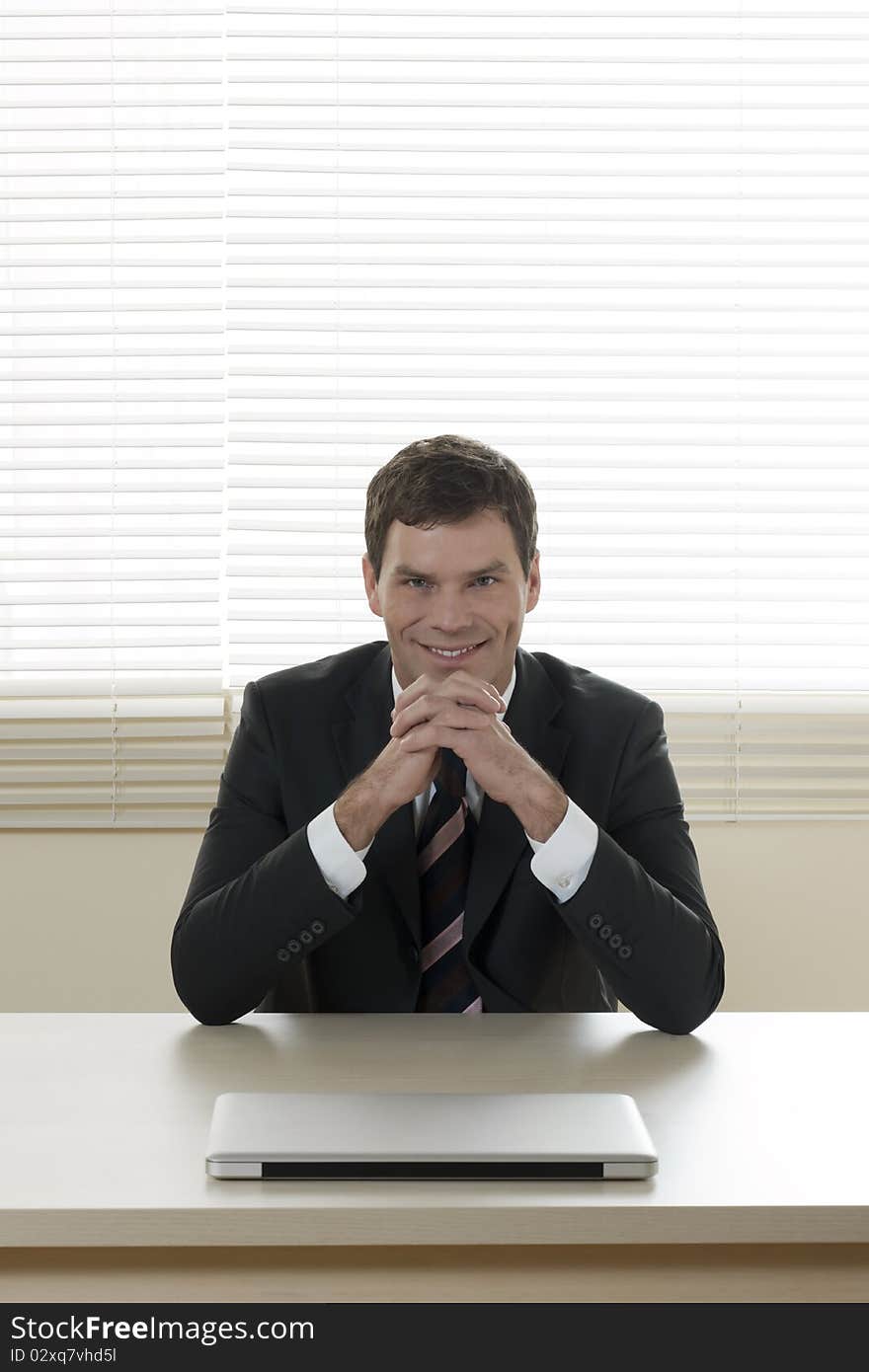 Portrait of a smiling businessman at his desk. Portrait of a smiling businessman at his desk