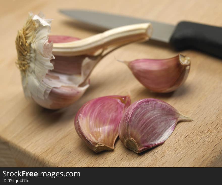 Garlic Bulbs And Cloves On Wooden Chopping Board