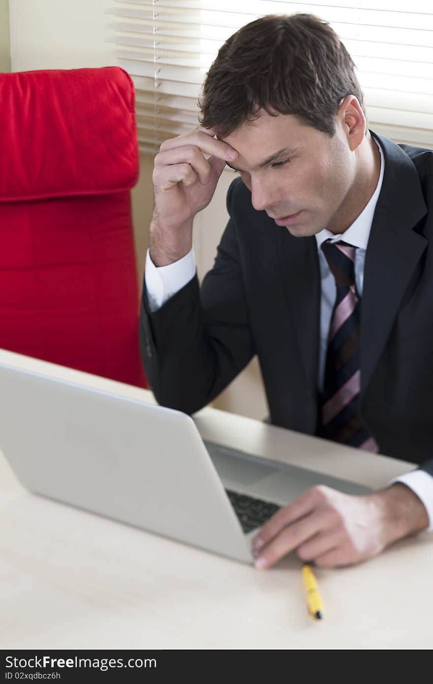 Businessman working on laptop in his office