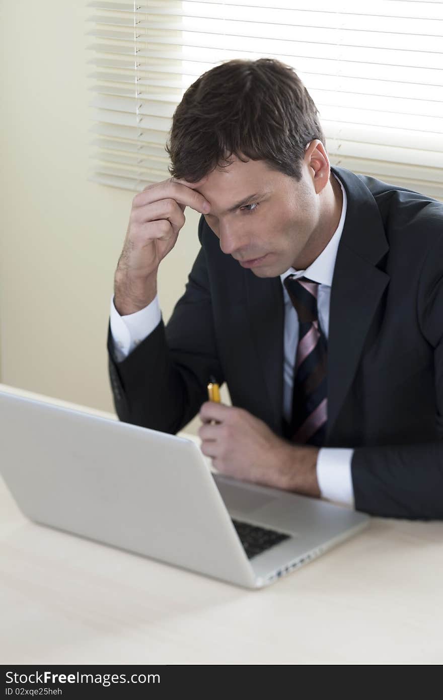 Concentrated Businessman working on laptop in his office