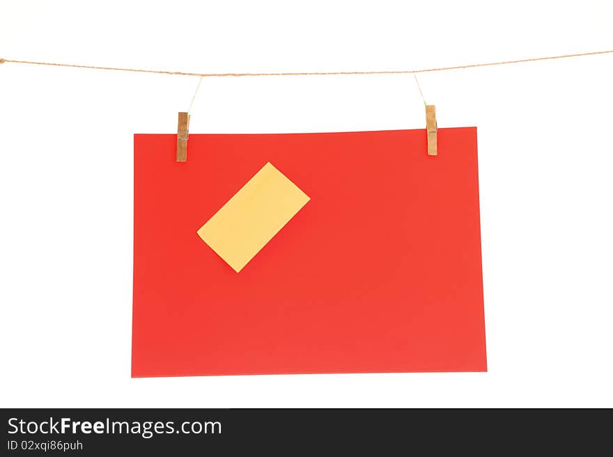 Red blank paper sheet on a clothes line. Isolated on white background. Red blank paper sheet on a clothes line. Isolated on white background.