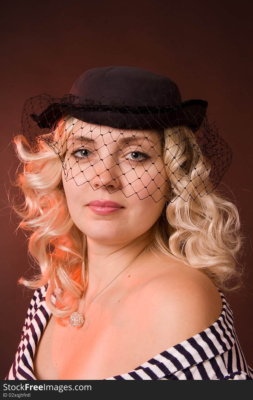 Photo of beautiful young woman of blonde in a hat with a veil. Photo of beautiful young woman of blonde in a hat with a veil