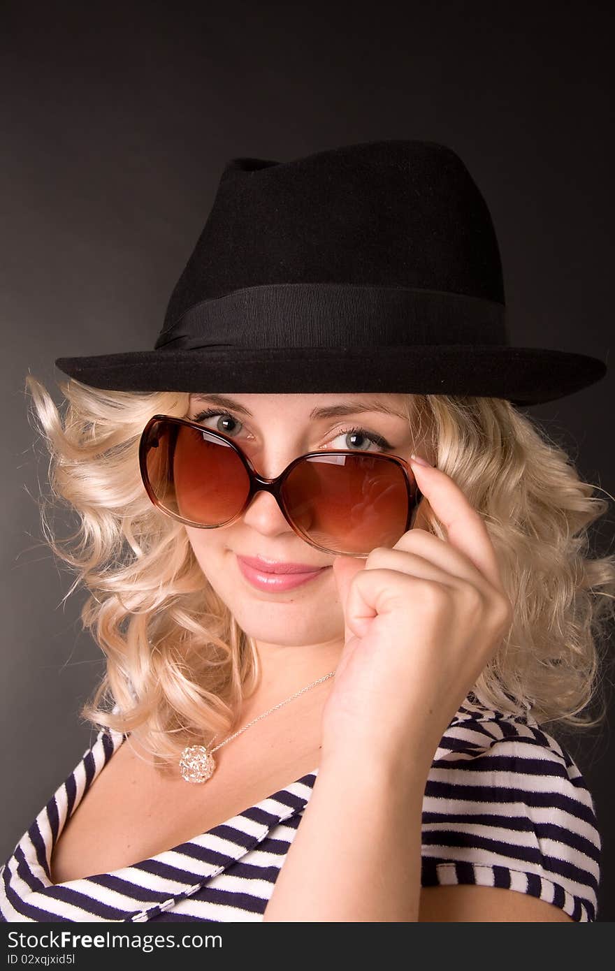 Photo of beautiful young woman of blonde is in sunglasses and hat