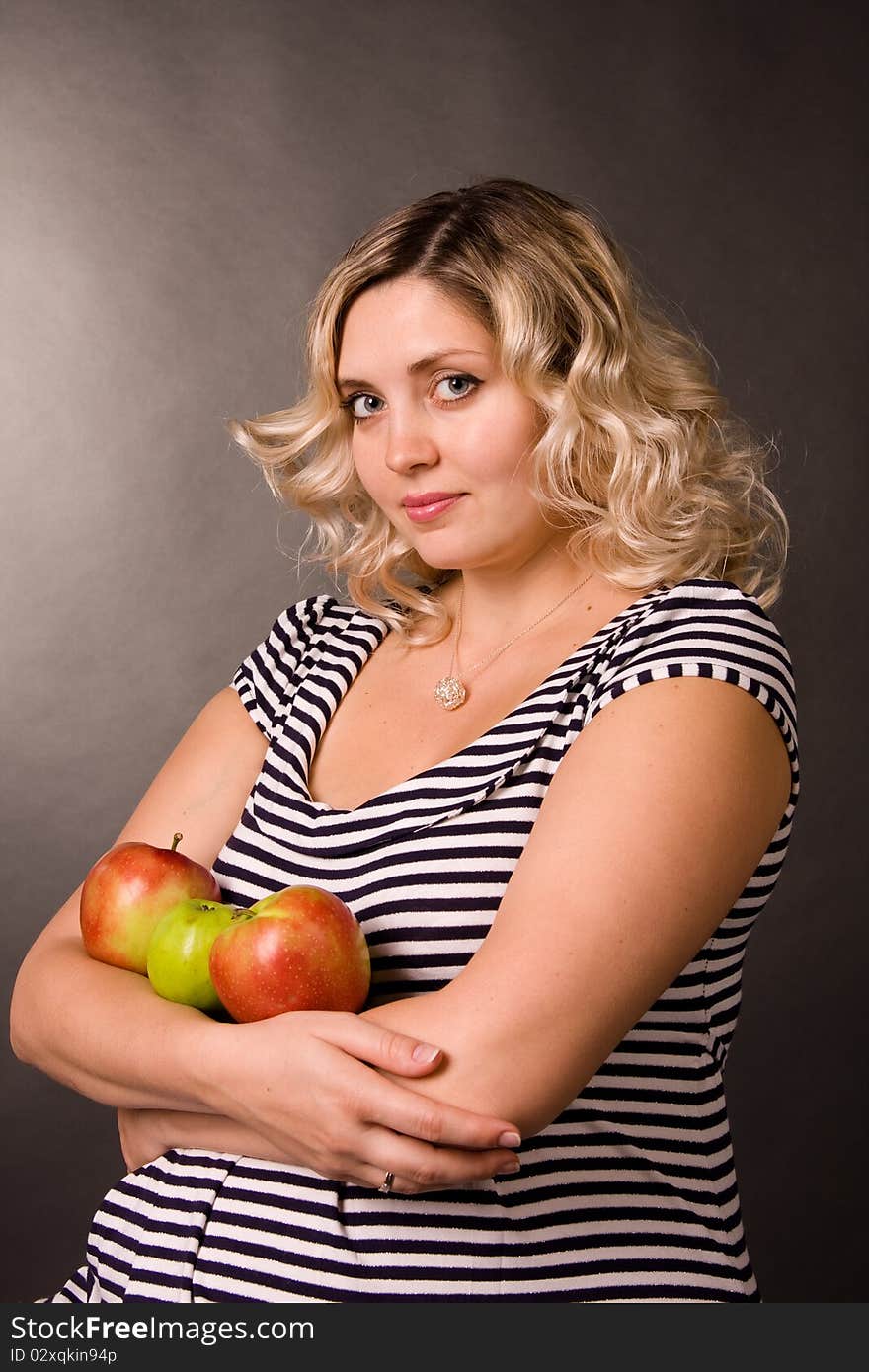 Photo of beautiful young pregnant woman of blonde with apples.