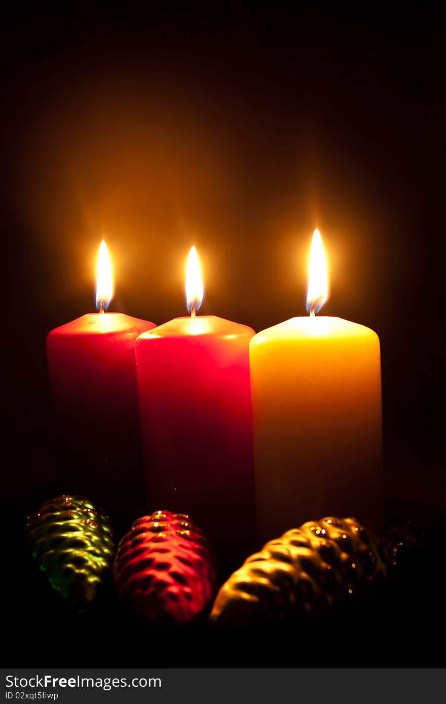 Group of three candles and three glass toys in darkness. Group of three candles and three glass toys in darkness