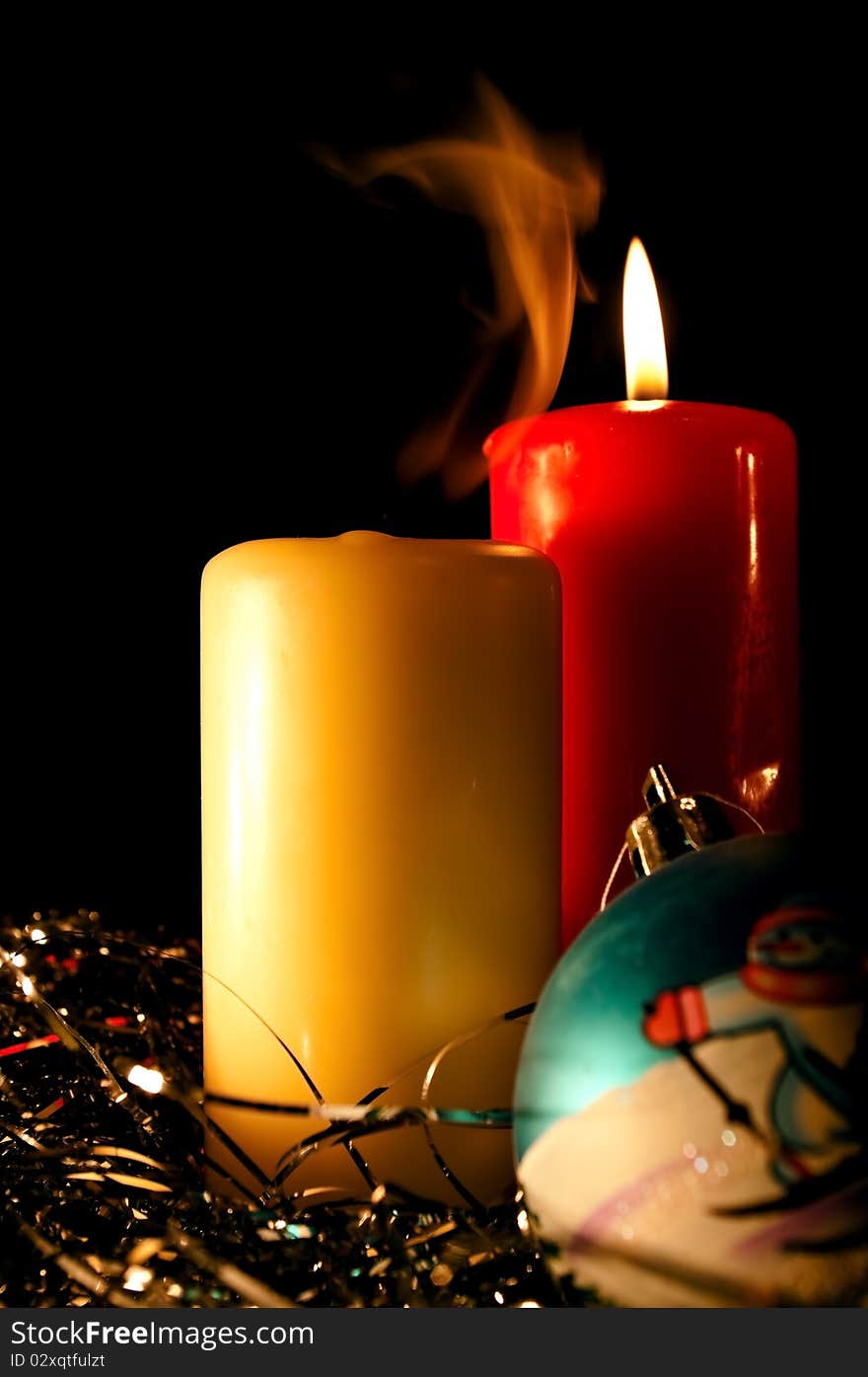 Two candles and New Year's sphere on a black background. Two candles and New Year's sphere on a black background