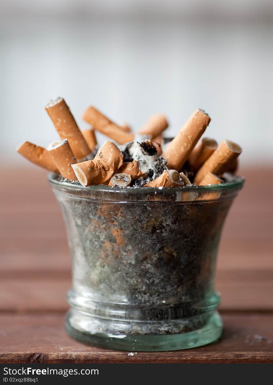 Ashtray full with butts on dirty table