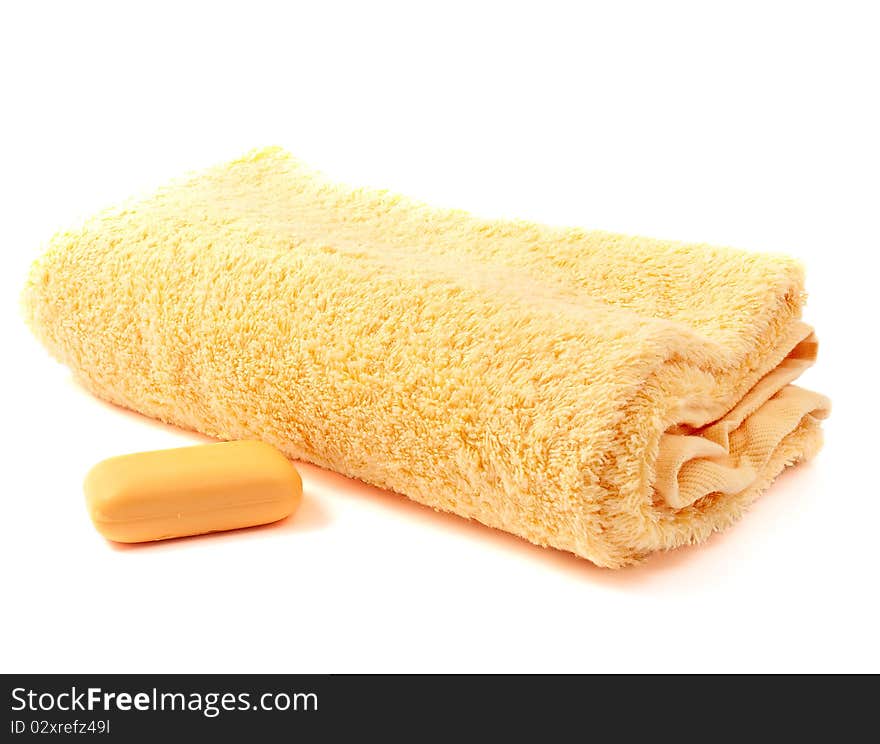 Yellow towel and soap on a white background