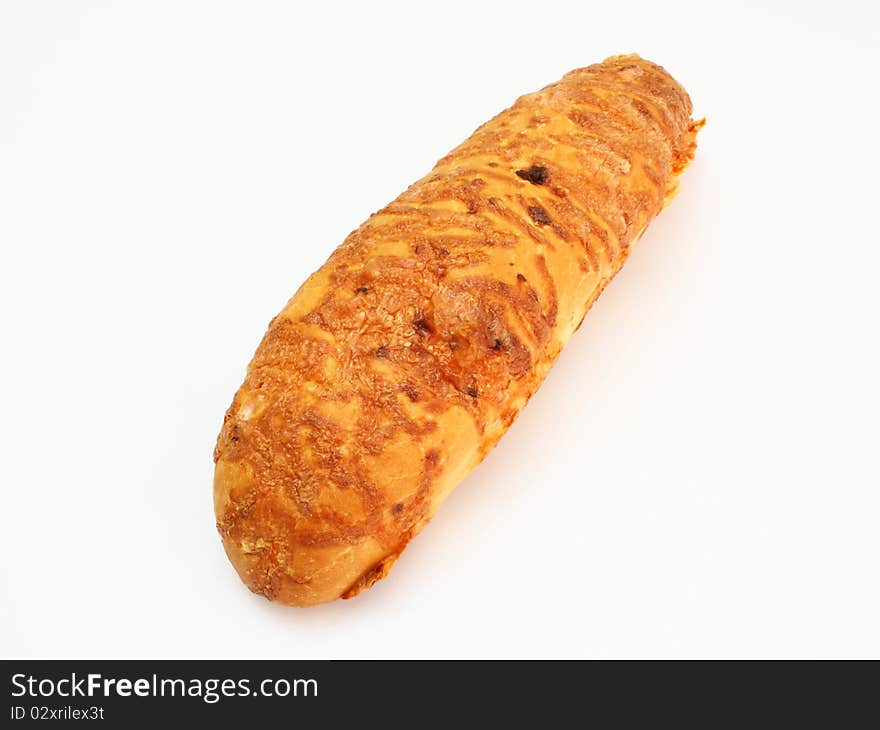 The ruddy long loaf of bread is strewed by cheese isolated on a white background