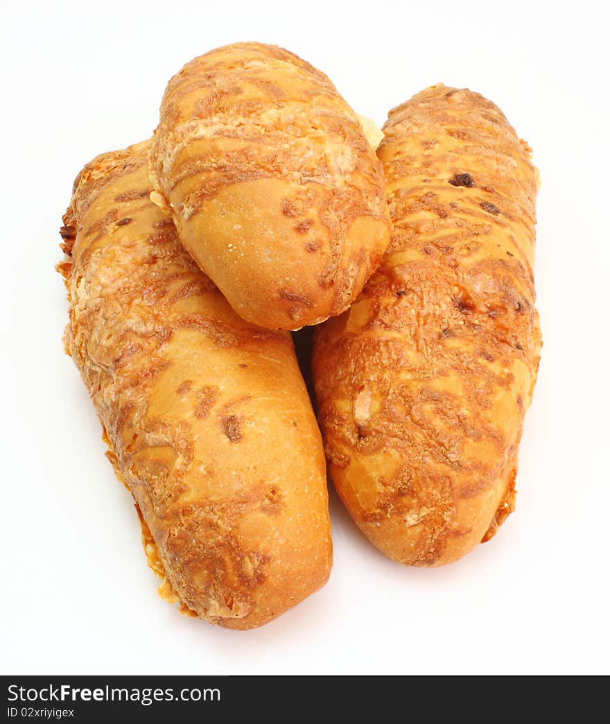 The ruddy long loaf of bread is strewed by cheese isolated on a white background