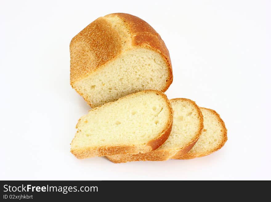 The ruddy long loaf of bread with the fried crust is isolated on a white background