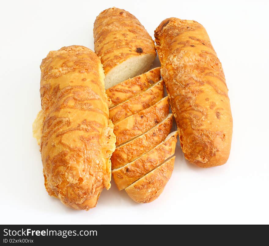 The ruddy long loaf of bread is strewed by cheese isolated on a white background