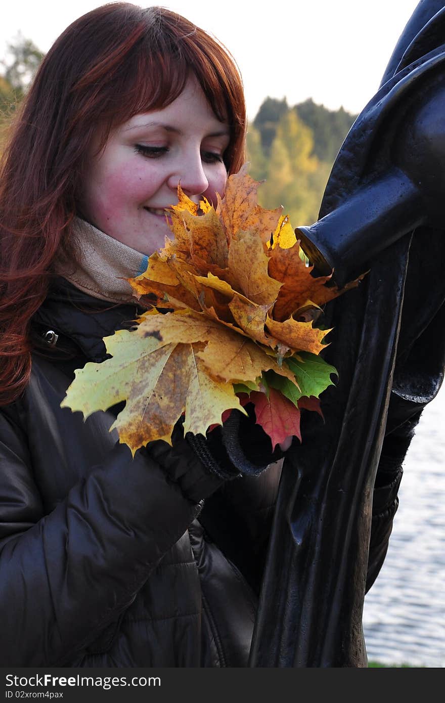 The girl is holding autumn leaves