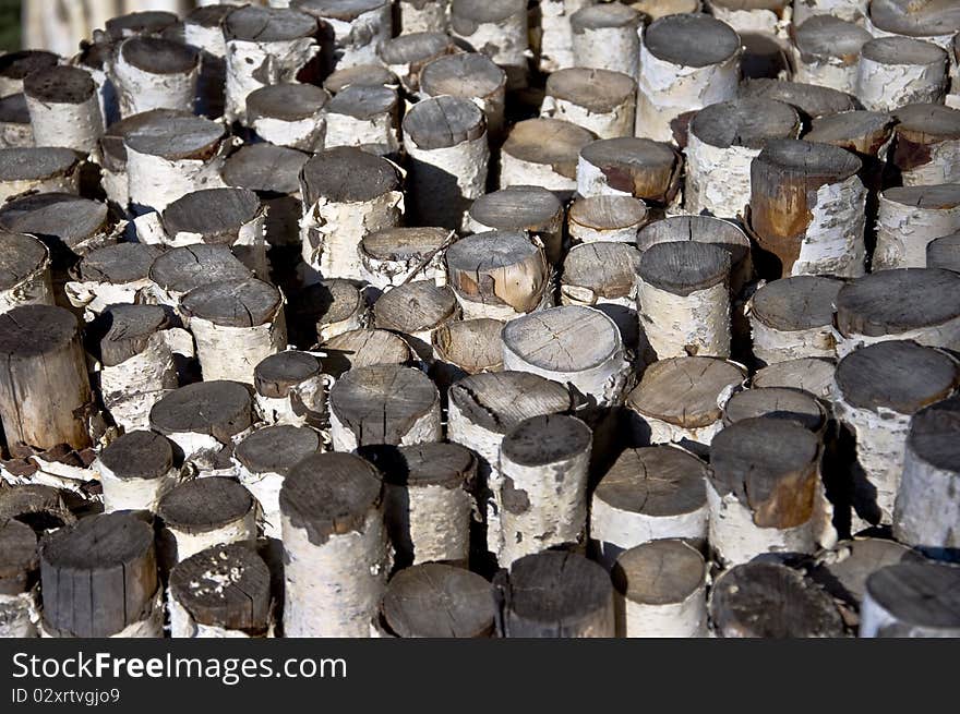 Sawn birch logs. Bundle of firewood and campfire. Close-up. Focus on the center of the frame.