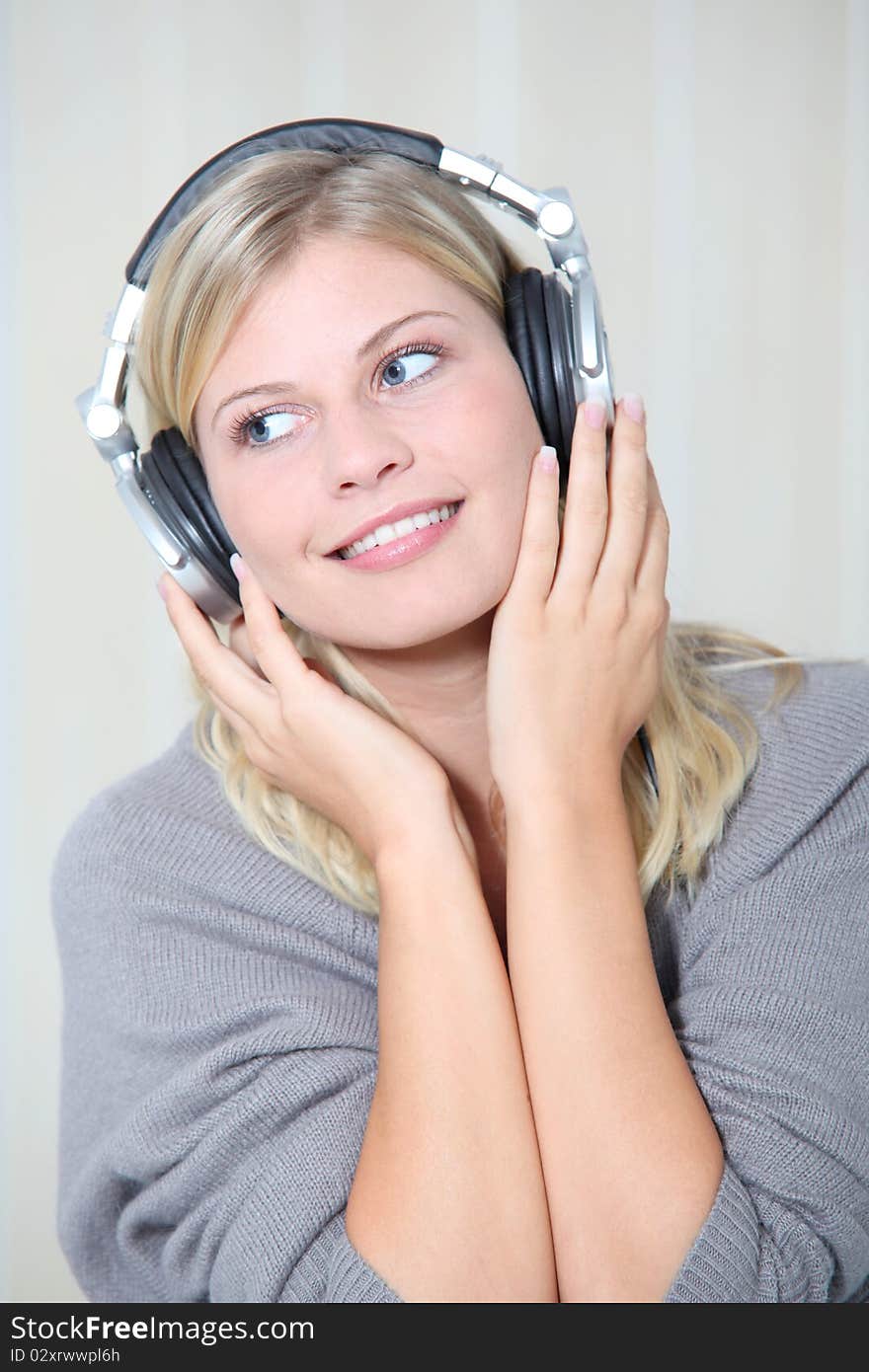 Beautiful blond woman at home with headphones on. Beautiful blond woman at home with headphones on