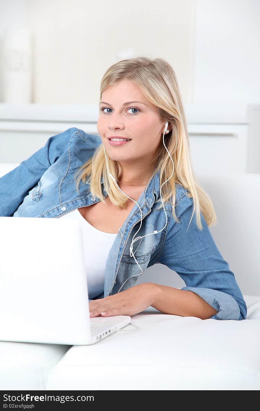 Beautiful blond woman listening to music on internet. Beautiful blond woman listening to music on internet