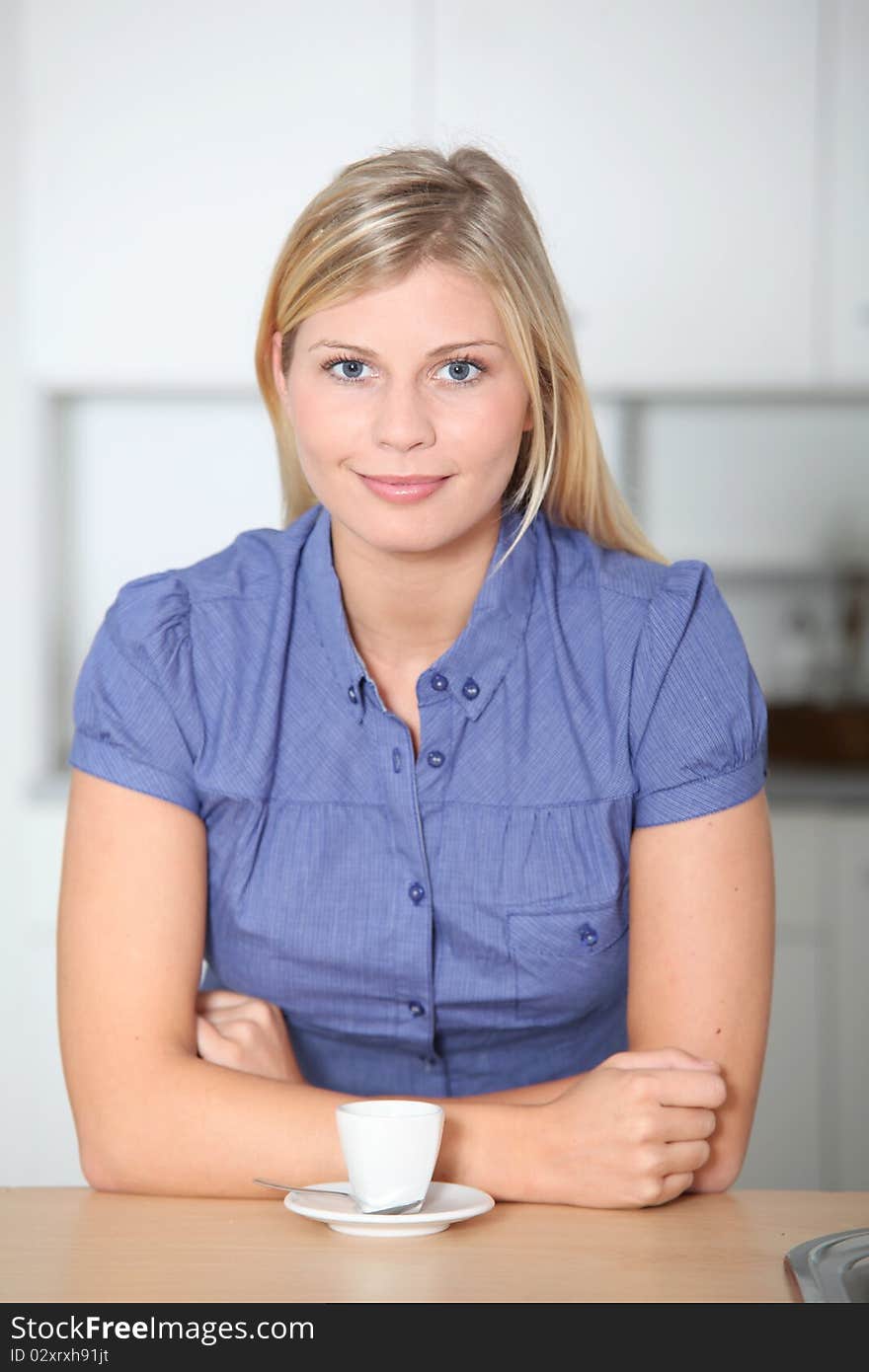 Smiling beautiful blond woman standing in kitchen. Smiling beautiful blond woman standing in kitchen