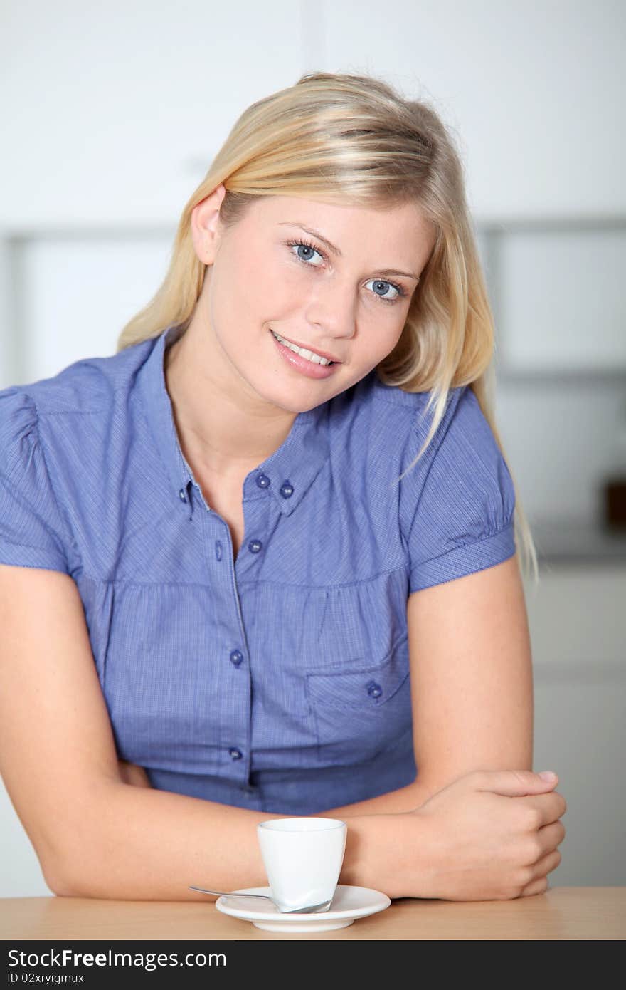 Smiling beautiful blond woman standing in kitchen. Smiling beautiful blond woman standing in kitchen