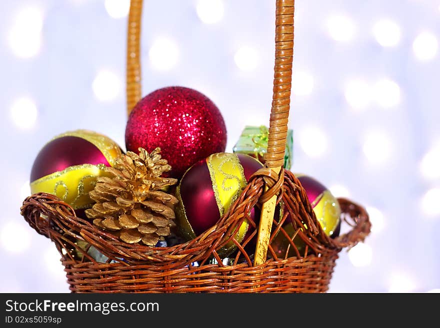 Christmas toys in a wicker basket on a background of lights. Christmas toys in a wicker basket on a background of lights