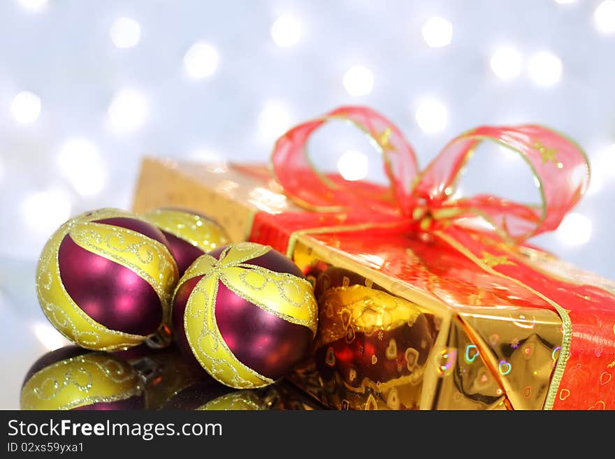 Christmas balls and gift box on the background lights