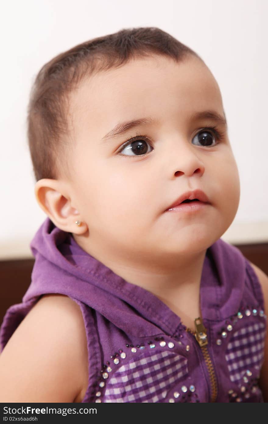 Serious baby looking up over white background