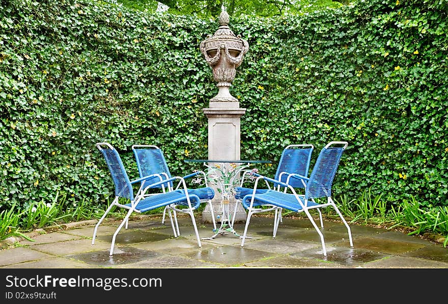 Four wicker chairs and glass table in the garden