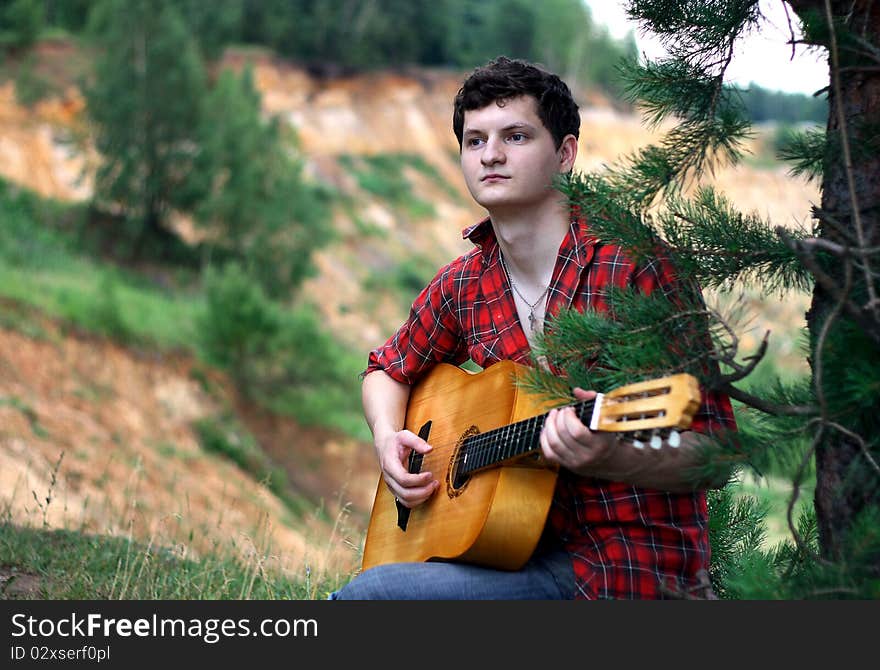 A lone young man with a guitar. A lone young man with a guitar