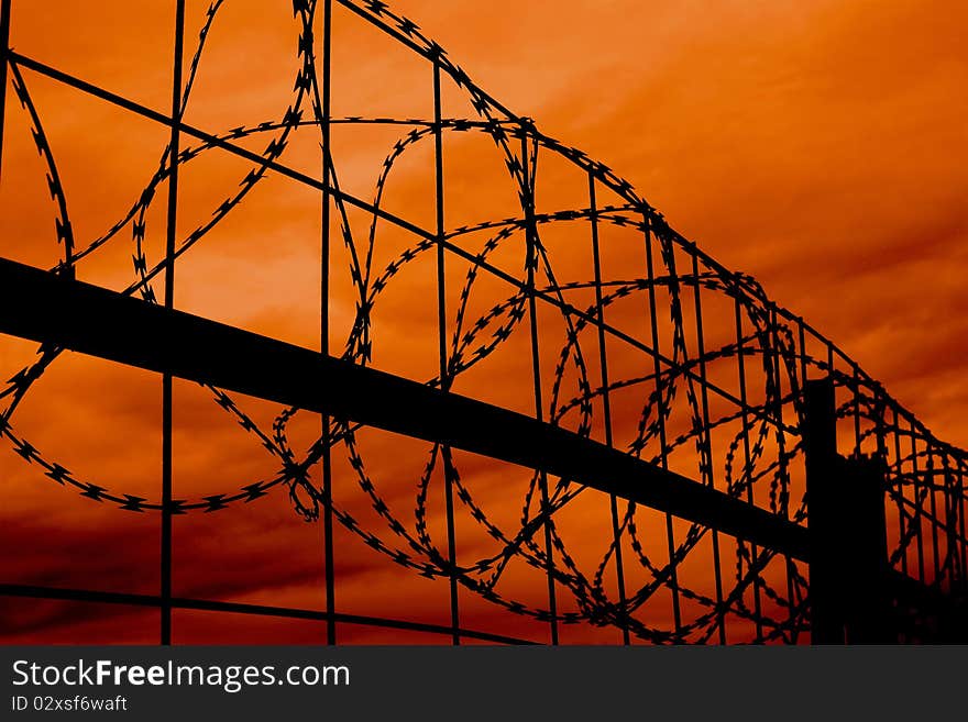 Silhouette of razor wire against a sunset sky. Silhouette of razor wire against a sunset sky