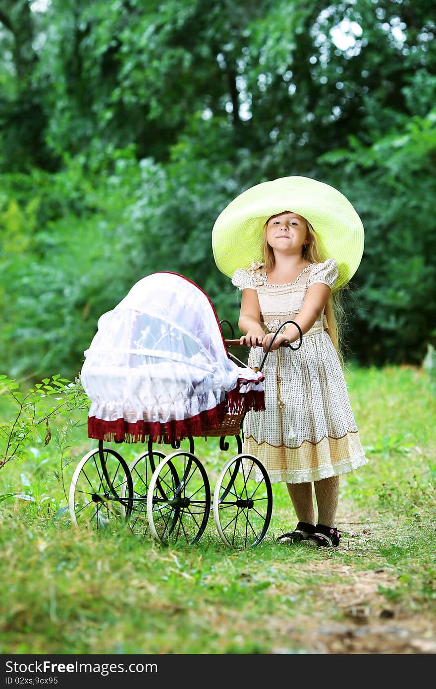 Shot of a cute girl walking with baby buggy at summer park. Shot of a cute girl walking with baby buggy at summer park.