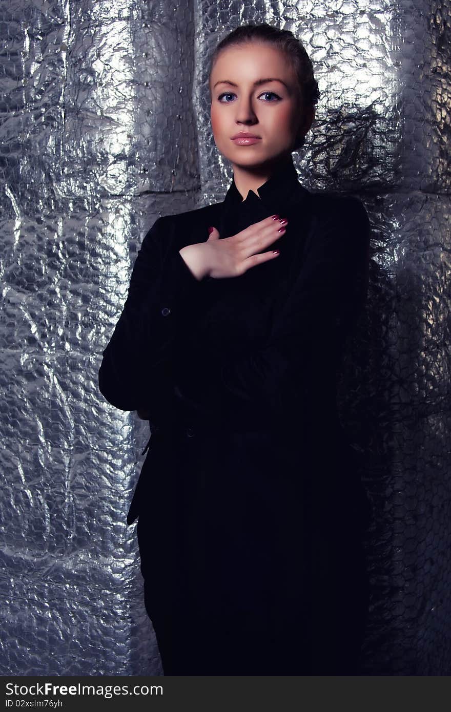 Young beautiful woman posing in a studio on a silver background. Young beautiful woman posing in a studio on a silver background