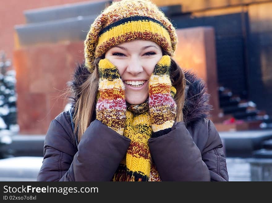 Cheerful girl in winter hat and mittens