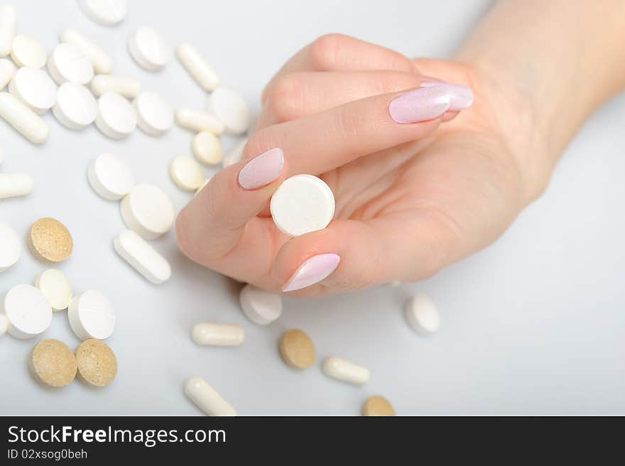 Beautiful woman hand with perfect manicure holding many medical pills. isolated on white background. Beautiful woman hand with perfect manicure holding many medical pills. isolated on white background