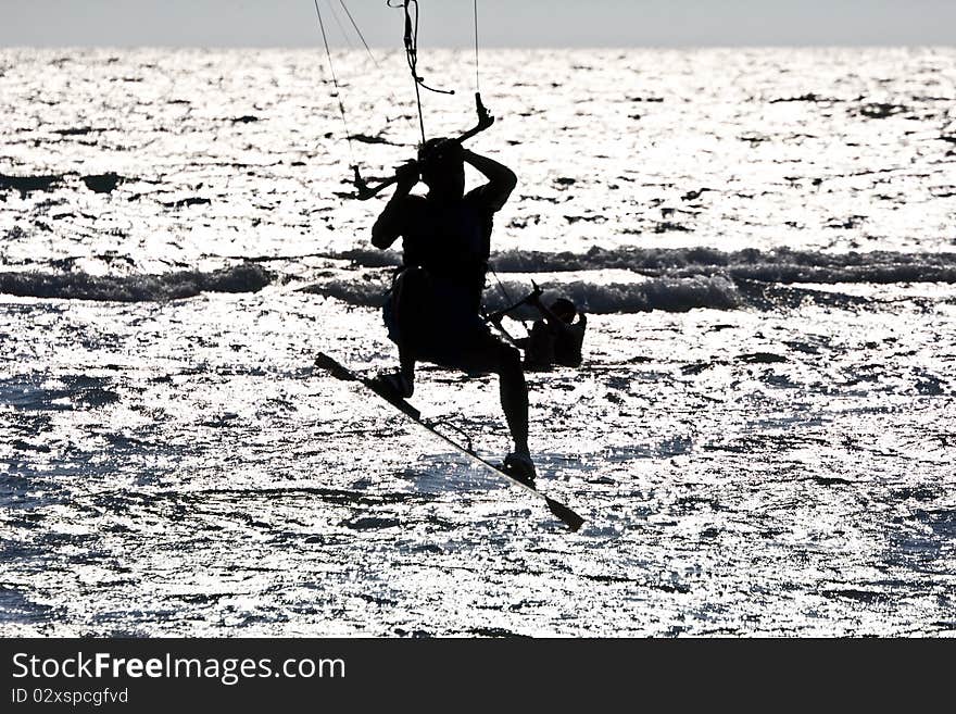 Silhouette of a kitesurfer jumping in the waves. Silhouette of a kitesurfer jumping in the waves