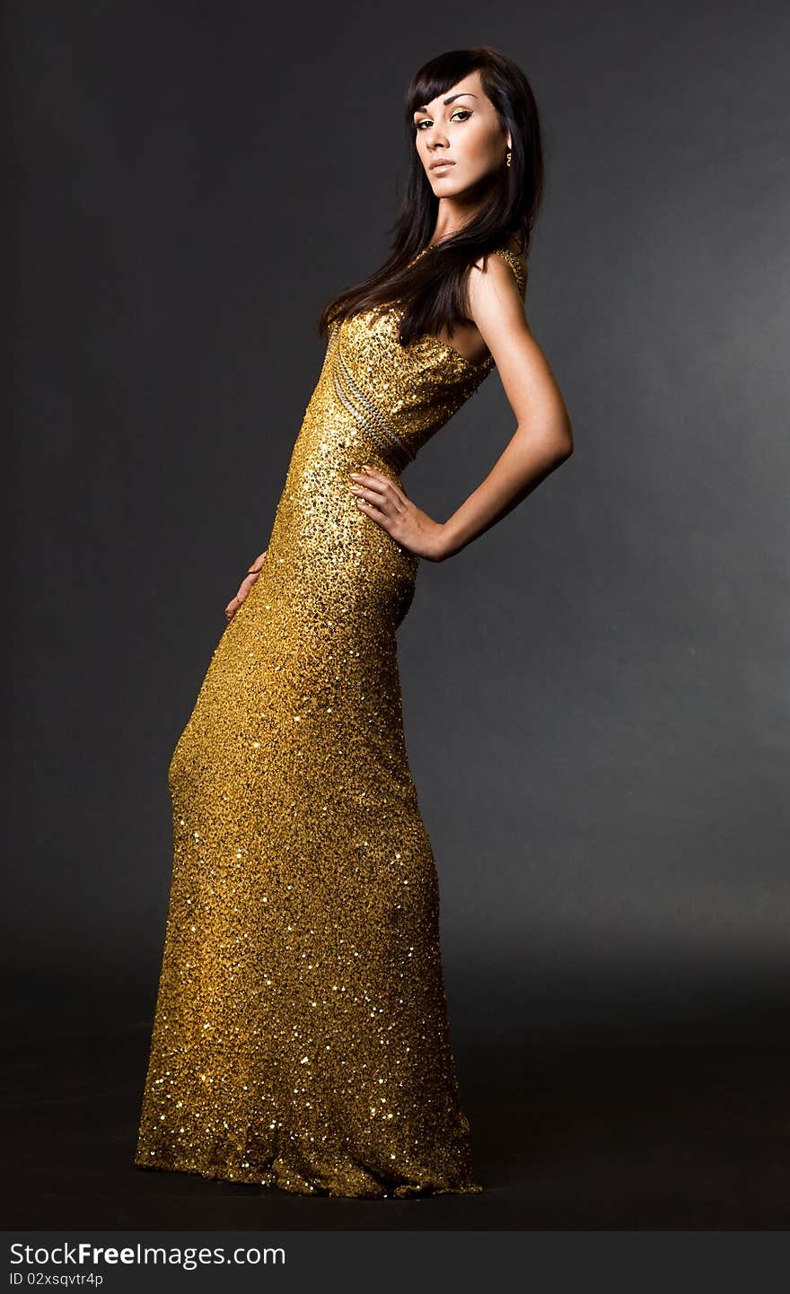 Beautiful fashionable woman in golden dress