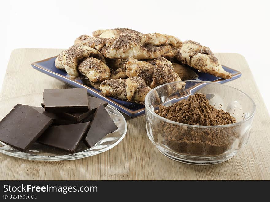 Chocolate Rugelach pastries with chunks of chocolate and bowl of cocoa.