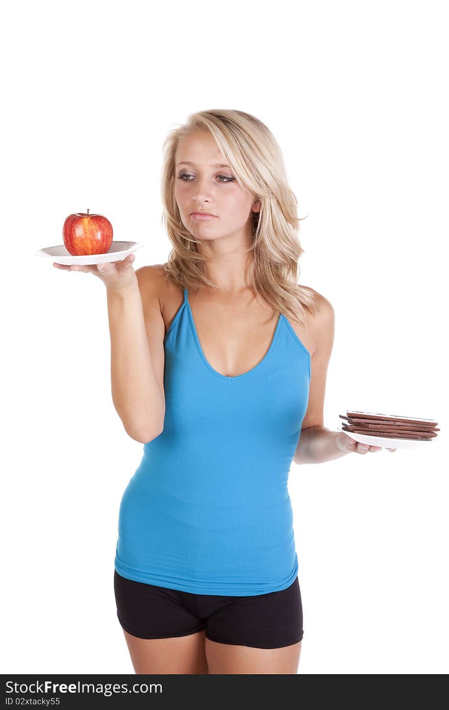 A woman is looking at an apple, but wanting to eat the chocolate. A woman is looking at an apple, but wanting to eat the chocolate.