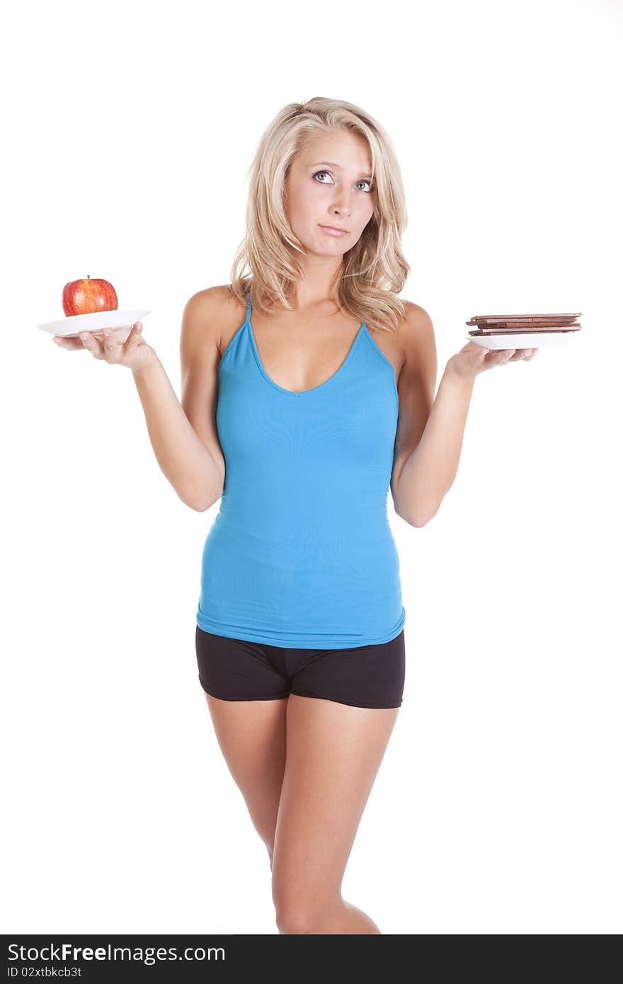 A woman is trying to decide between eating chocolate, or fruit. A woman is trying to decide between eating chocolate, or fruit.