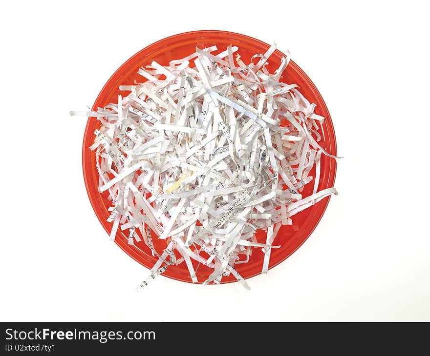 Red plastic dish full of paper strips on the white background