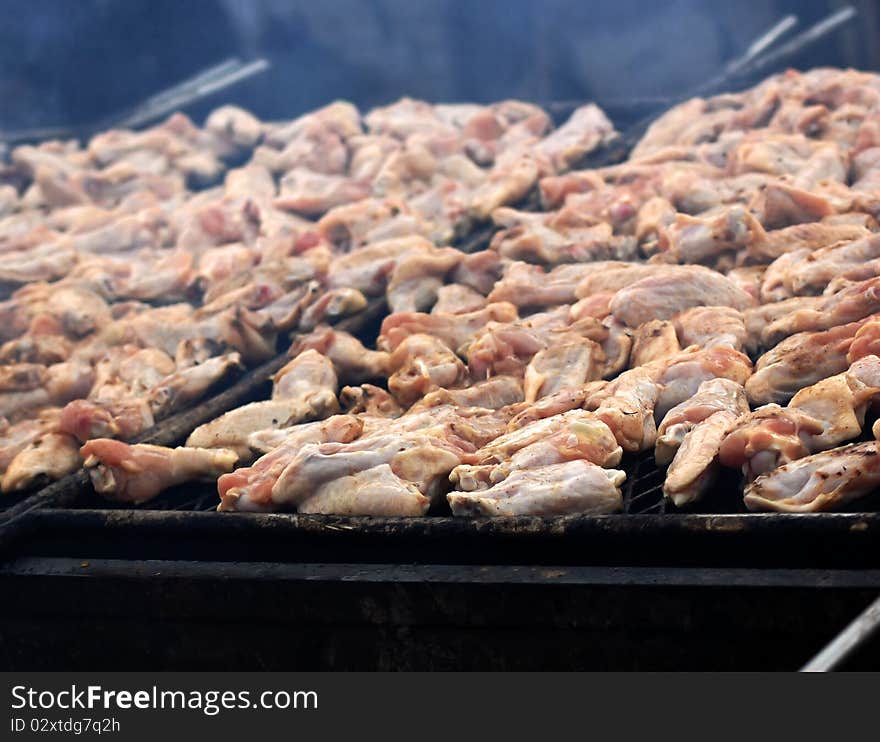 Smoke infused chicken wings cooking on a fire barbecue grill. Smoke infused chicken wings cooking on a fire barbecue grill.