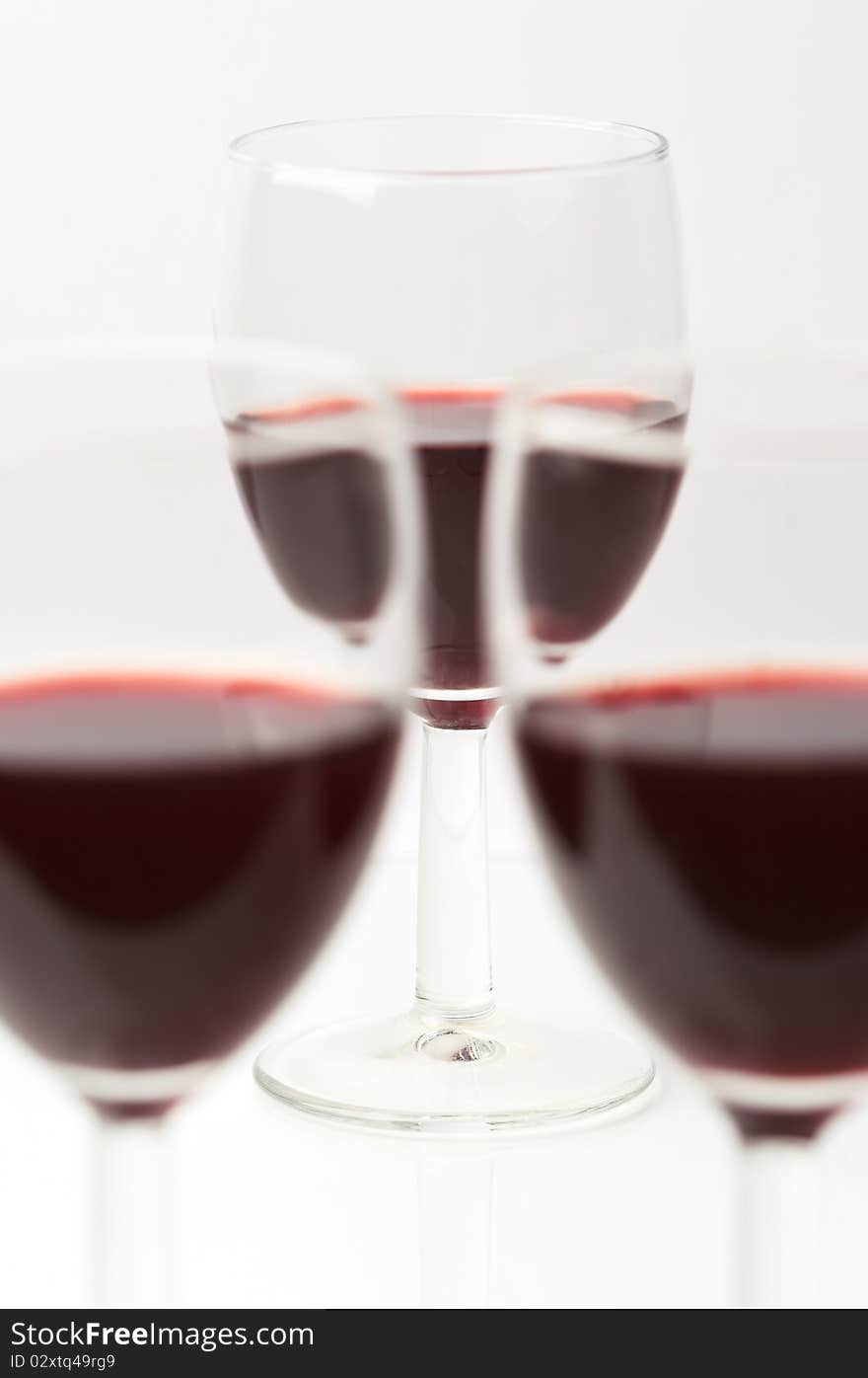 Three glasses with red wine on white. Three glasses with red wine on white.