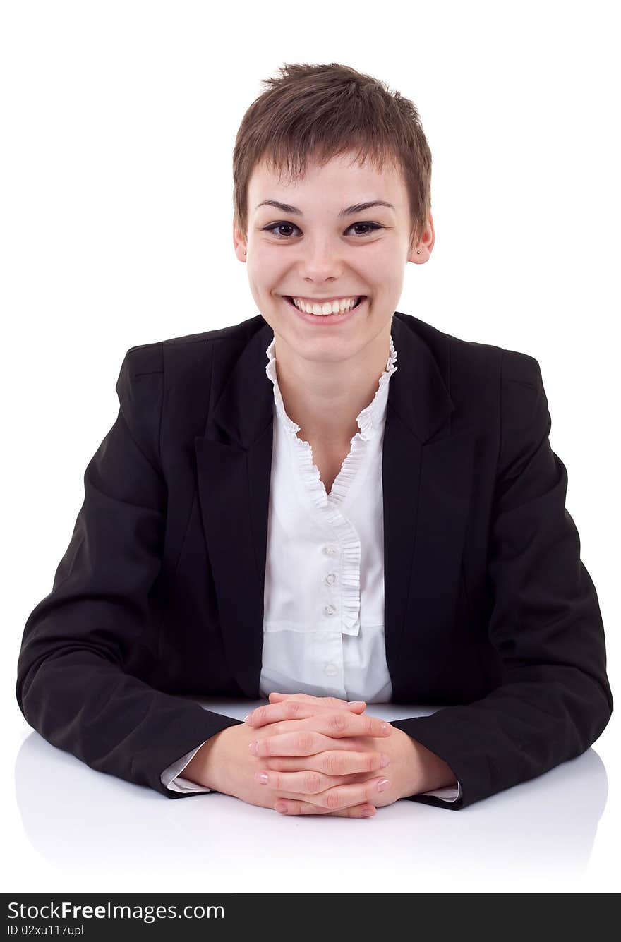 Young beautiful business woman behind the desk, isolated