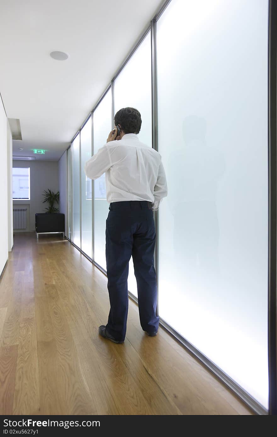 Businessman talking on mobile phone in office lobby